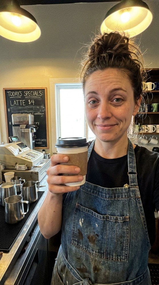 A barista holding up a coffee
